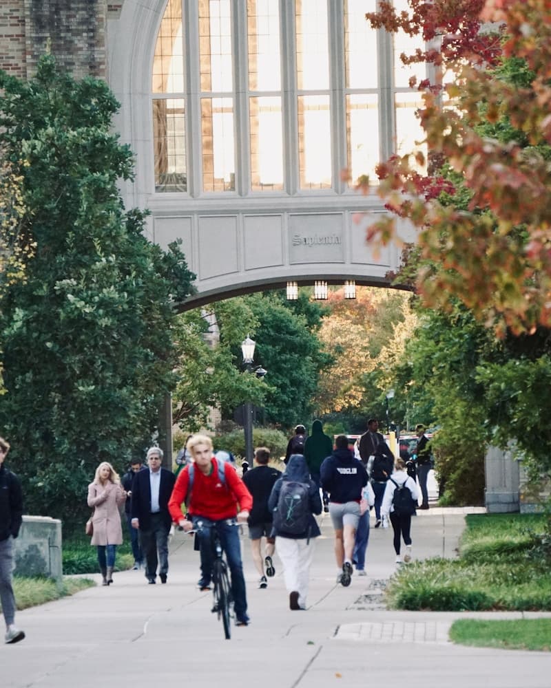 Students walking and biking on a college campus path